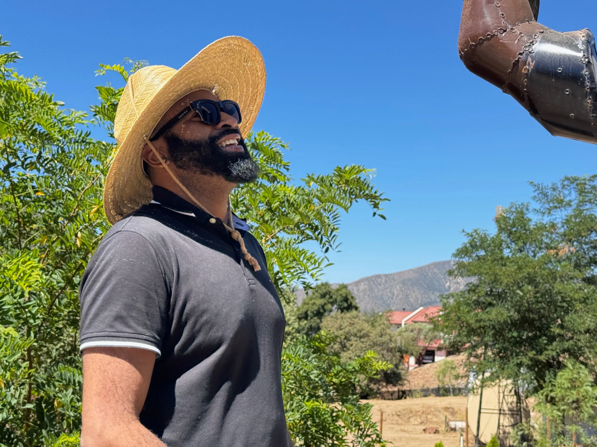 Portrait of director Jovon Dizard on the ranch, looking up at the metal horse.